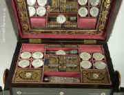 The top lifts to reveal a fully fitted sewing box. It has 8 mother of pearl spools, cut crystal scent bottle all set off with brocaded silk and gold embossed leather. Enlarge Picture