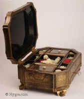 SB474: A very fine Chinese export lacquer sewing box of complex curved octagonal form, with fine decoration of oriental scenes framed within cartouches standing on gilded bat feet. The background is filled with diaper designs of stylized flora. Inside there is a lift out tray with supplementary lids and sewing tools made of turned and carved ivory. The box has gilded side handles and hinges. Circa 1835. Enlarge Picture